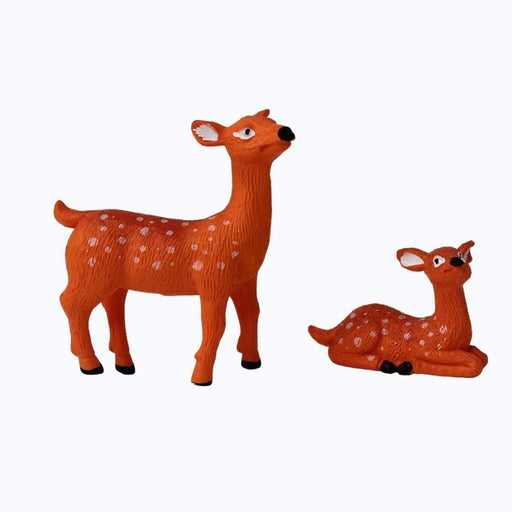 Assortment of small animal resin statues  placed on a mossy log in an outdoor setting.