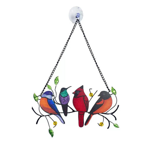 Colorful metal suncatcher with four songbirds (blue, purple, red cardinal, and orange/black bird) perched on a black metal branch with green leaves and yellow beads, hanging from a chain with a white suction cup.