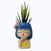 Cartoon girl face planter with blue hair and a pink bow, holding a small succulent plant.