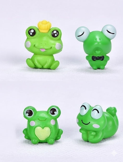 Four small, green, whimsical frog figurines. One wears a yellow crown, one has a black bow tie, one has a heart on its chest, and one is smiling while lying down.