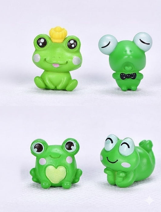 Four small, green, whimsical frog figurines. One wears a yellow crown, one has a black bow tie, one has a heart on its chest, and one is smiling while lying down.