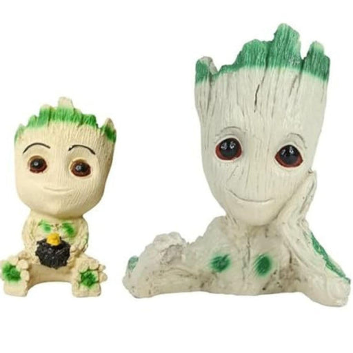 Two white resin Baby Groot figurines with green moss details; one is a mini planter with his hand on his face, and the other is a small sitting figurine, both on a white background.