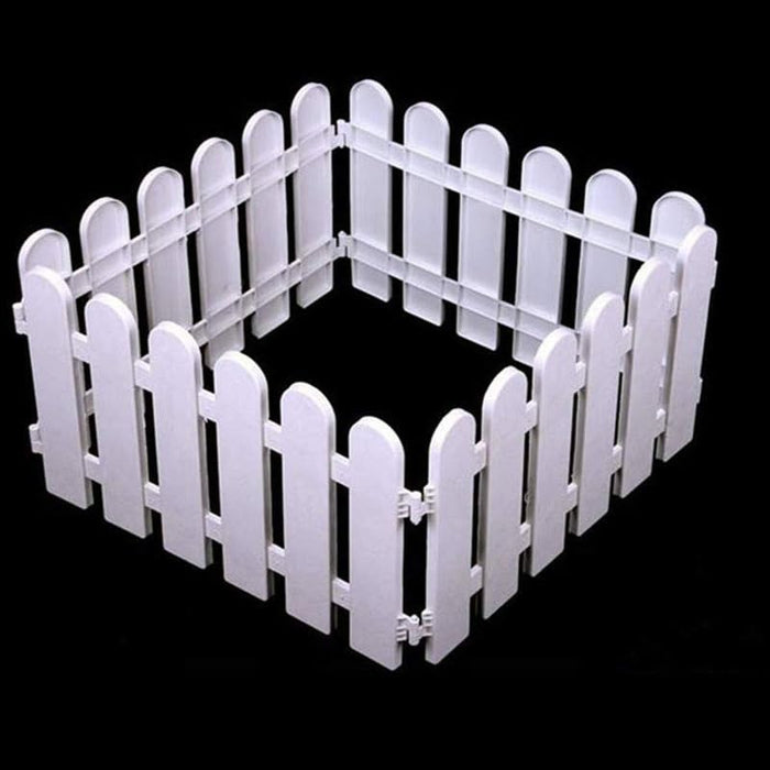 white plastic picket fence arranged in a small square shape against a solid black background, showing interlocking hinge connectors on the panel edges.