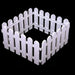 white plastic picket fence arranged in a small square shape against a solid black background, showing interlocking hinge connectors on the panel edges.