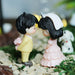 Miniature bride and groom couple figurines in a fairy garden setting, romantic resin wedding cake topper or decorative terrarium accessory.