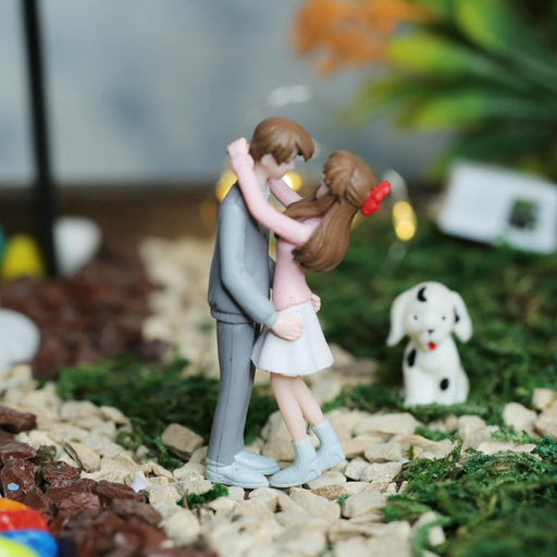 Miniature hugging couple figurine in a fairy garden, decorative resin romantic statue for terrariums, gift for couples, and cake topper.