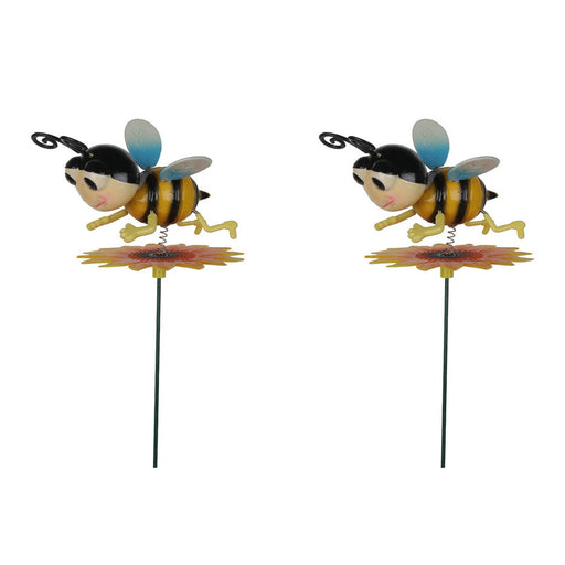 Two decorative metal bumblebee garden stakes featuring cartoon-style bees with blue wings hovering over yellow sunflowers on thin green metal rods, isolated on a white background.