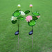 Two solar-powered lotus flower garden stakes featuring green stems and illuminated white and pink lotus blossoms