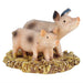 A miniature resin figurine of a spotted pink mother pig and her piglet standing on a textured yellow hay base, isolated on a white background.