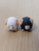 Pair of miniature black and white sheep figurines with curled horns, decorative resin ram statues for fairy gardens, terrariums, and desk decor.