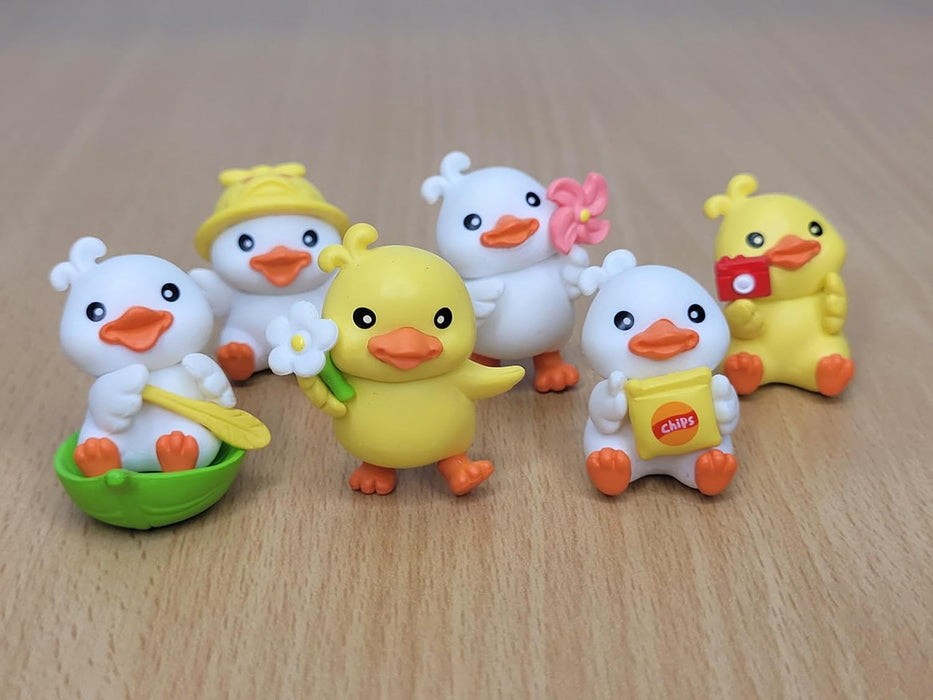 Set of six miniature tourist duck figurines with accessories like a camera, chips, and sun hat, decorative resin ducks for fairy gardens and desk decor.