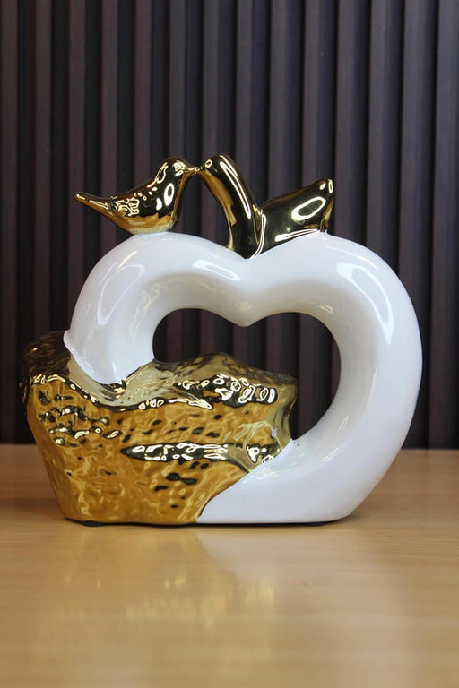 Modern abstract white heart ceramic sculpture with gold-plated birds and a textured metallic base, elegant romantic home decor centerpiece.