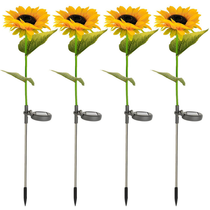 Four realistic artificial sunflower garden stakes with integrated solar panels and silver metal ground spikes, isolated on a white background.