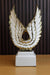 Modern white ceramic wing sculpture with gold-plated feather edges on a white pedestal, elegant luxury home decor and trophy-style centerpiece.