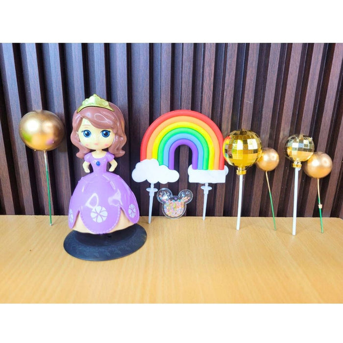 Princess Sofia inspired cake topper set in plastic packaging featuring a doll in a purple dress, gold disco balls, and a red "PARTY" bow header.