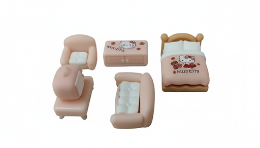 A high-contrast image of a miniature, 5-piece pink and white Hello Kitty dollhouse furniture set. The set includes a bed with a Hello Kitty comforter, a dresser/cabinet, two armchairs with white cushions, and one chaise lounge chair.