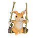 Adorable resin bunny figurine sitting on a hanging tree branch swing with rope and green leaf details, isolated on a white background.