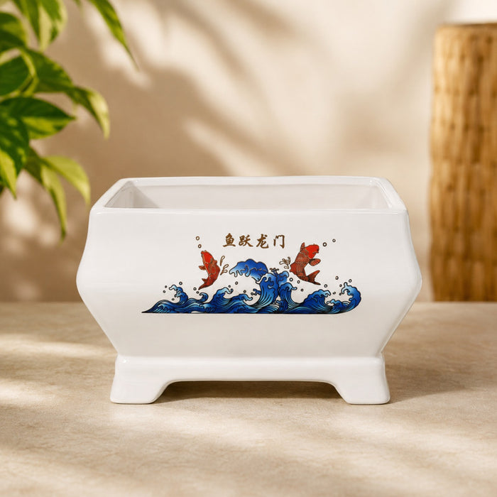 white rectangular ceramic planter featuring a koi fish and wave design sitting on artificial grass