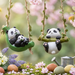 Hanging resin garden statue of a mother and baby panda sitting in a green leaf-shaped swing suspended by a leaf-wrapped jute rope.