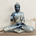 A serene Buddha statue in a seated meditation pose, featuring a matte black finish with gold-toned textured robes, set against a modern vertical wood-slat background.