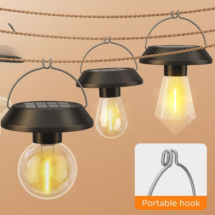 Three portable solar-powered hanging LED lights with clear bulbs suspended on a rustic rope line