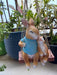 Hanging Mother & Baby small ceramic bunny figurines sitting on a miniature wooden swing,