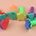 A collection of colorful children's foam sponge paint stamps with assorted shapes like a heart, star, flower, and hand, arranged on a light background.