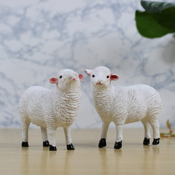 Two cute white sheep figurines with textured wool, pink ears, and black hooves