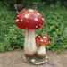 Handmade ceramic twin red toadstool mushroom garden statue placed on a stone
