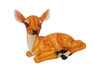 A standard-sized resting deer garden statue with white spots positioned on green grass amongst garden foliage