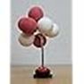 A miniature balloon cluster with red and white clay balloons on a silver wire stand, standing on a wooden surface against a plain background.