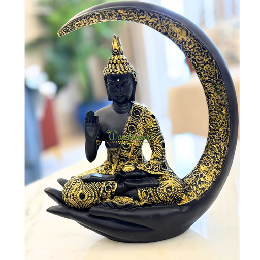 Black and gold Buddha statue sitting in a meditative pose on a large hand base, framed by a matching crescent moon arch.