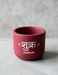 Handmade maroon terracotta plant pot featuring the word "Shukr" (gratitude) in white script with small star accents on a grey background.