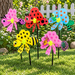 Five colorful insect-shaped pinwheels including a butterfly, ladybug, dragonfly, bee, and peacock staked in a green lawn