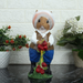 Hand-painted figurine of a rabbit dressed as a gardener in a hat, white shirt, and blue trousers, holding red berries