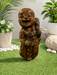 Laughing Buddha figurine with a glossy marbled wood-tone finish and joyful expression, displayed on a glass table.
