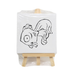 A small square canvas featuring a line-art drawing of a fish sitting on a light-colored wooden display easel, packaged in clear plastic.