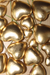 A close-up view of multiple metallic gold puffed heart decorations on thin green wire stems, scattered across a light wooden surface in image_e25c97.jpg.