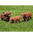 Three realistic plastic farm animal figurines—a shaggy adult Highland cow, a smaller brown cow, and a calf—standing on vibrant green artificial grass.