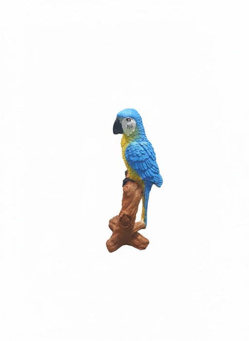 resin parrot garden statue, blue and yellow macaw perched on a brown branch/log.