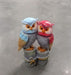 A resin figurine of two colorful owls, one blue and one pink/red, standing together on small wooden posts wrapped with rope.