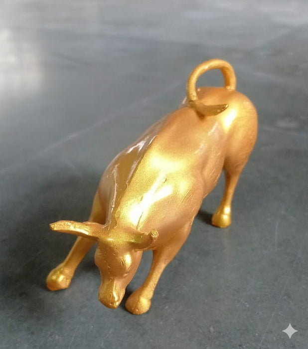 Aggressively posed bull showpiece with prominent horns and a looped tail. A decorative metallic bull showpiece.