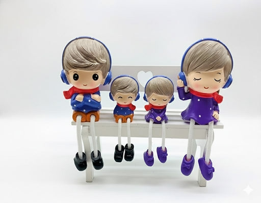 A set of four family figurines with dangling rope legs, featuring a father, mother, and two children wearing blue and purple winter outfits with red scarves and blue headphones,