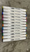 A set of 12  Dual Tip Art Sketch Markers lined up on a white background, showing the caps and barrels. The markers feature both Fine and Broad tips and have a color-coded end cap, displaying vibrant colors including purple, green, blue, yellow, orange, red, and black.