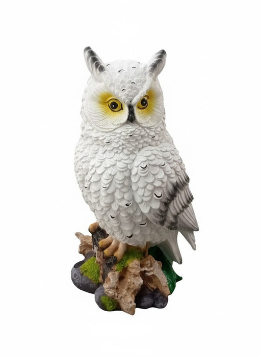 "Decorative resin statue of a white horned owl on a base of wood and stone."