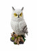 "Decorative resin statue of a white horned owl on a base of wood and stone."