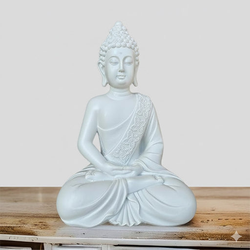 White or light grey serene Buddha statue sitting in a meditative posture, resting on a rustic wooden surface.