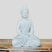 White or light grey serene Buddha statue sitting in a meditative posture, resting on a rustic wooden surface.
