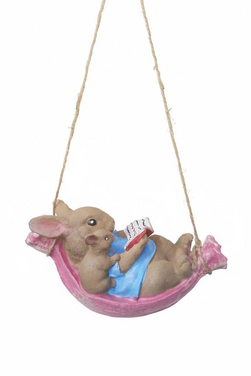 Cute bunny and mouse figurine reading in a pink hanging hammock.