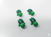 Four small, green, miniature plastic toy turtles with black and green shells on a white surface.